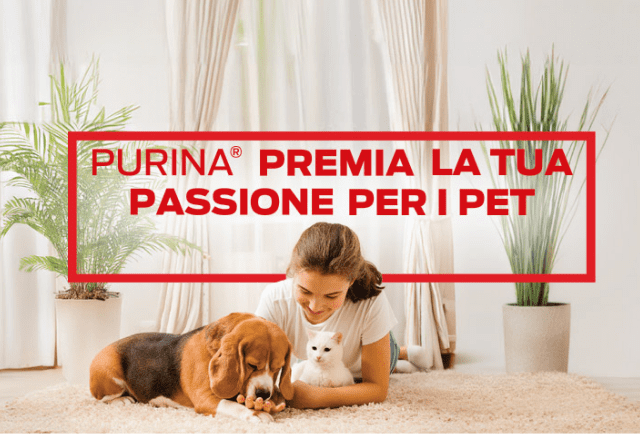 ragazza distesa su tappeto bianco con un cane e un gatto in braccio, sullo sfondo una tenda da salotto e due piante con vaso. Sopra di lei, il testo:'Purina premia la tua passione per i pet'